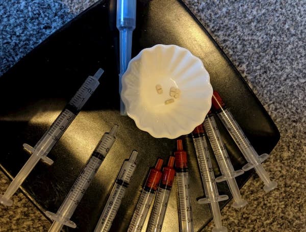 A plate holding numerous syringes and tablets