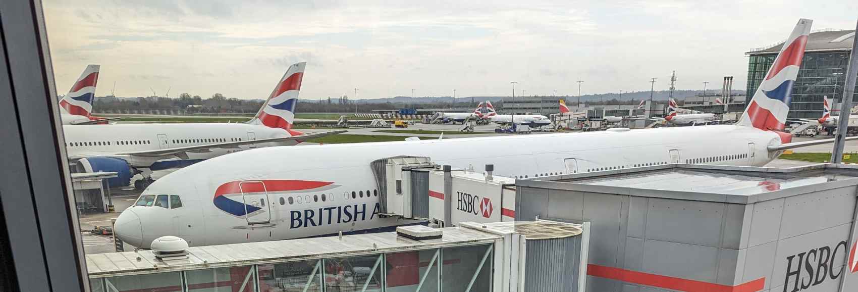 A view of a line of BA planes out of a window from the terminal