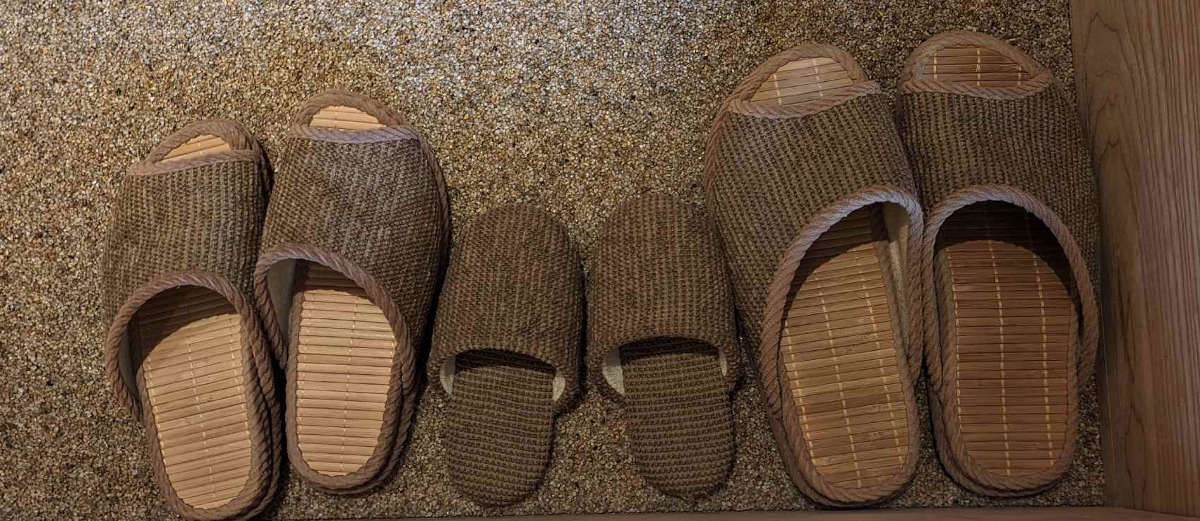Three pairs of slippers in a row. One for me, a larger one for my husband, and in between a tiny pair for the kid