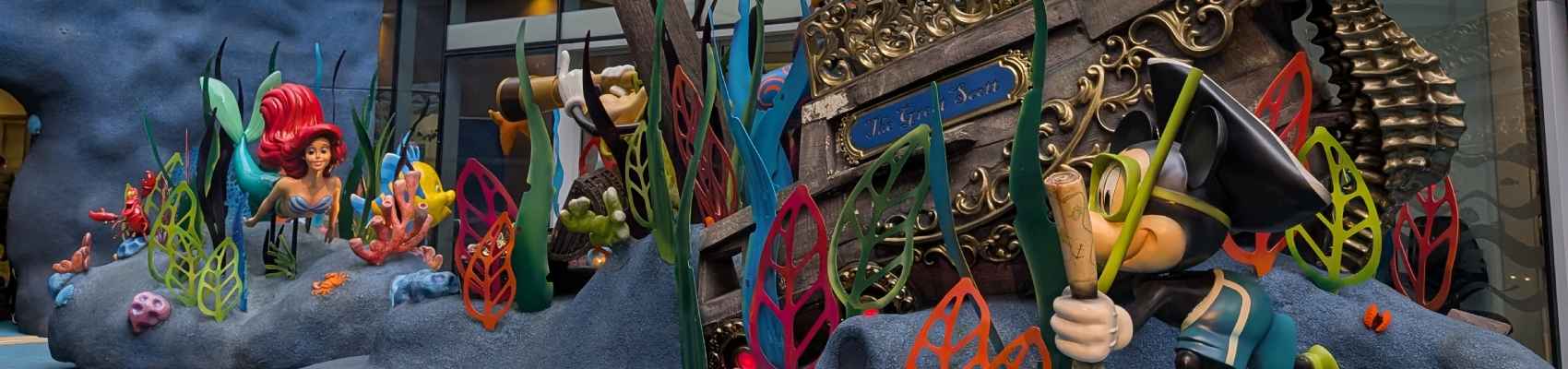 Narrow view of a Disney sculpture at GOSH, featuring a pirate ship. Mickey, and Ariel