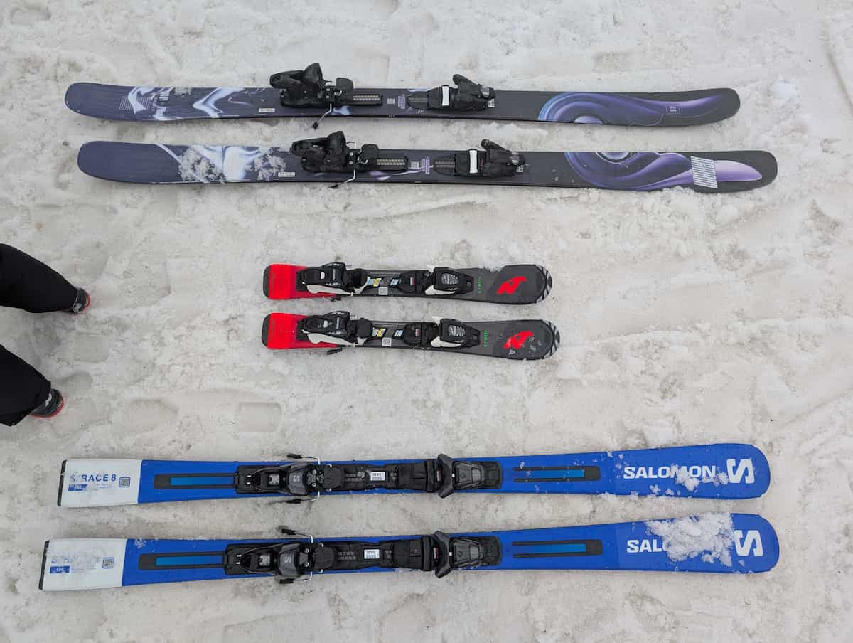 Three pairs of skis on snow – one big, one medium, and one teeny